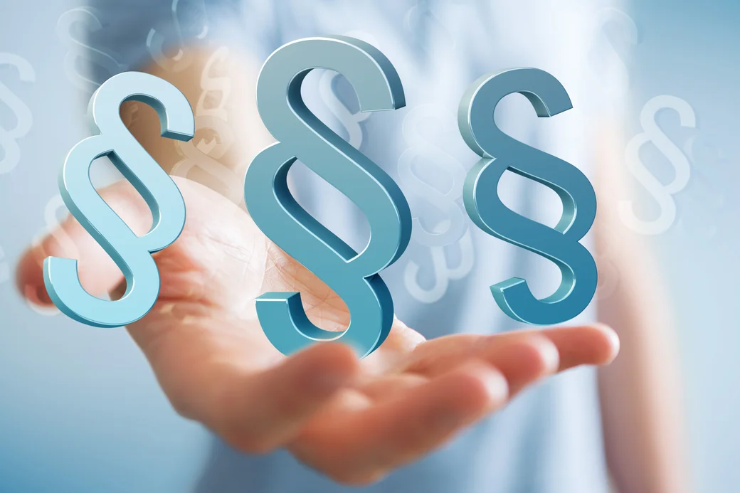 Paragraphenzeichen schweben über einer Hand